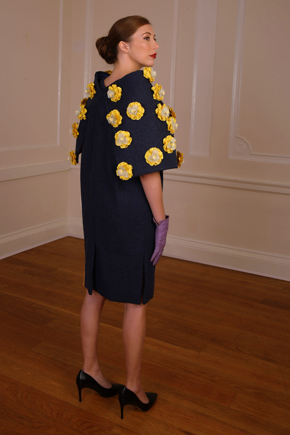 High end coat 100% wool tweed in a navy colour and adorned by silk flowers in yellow