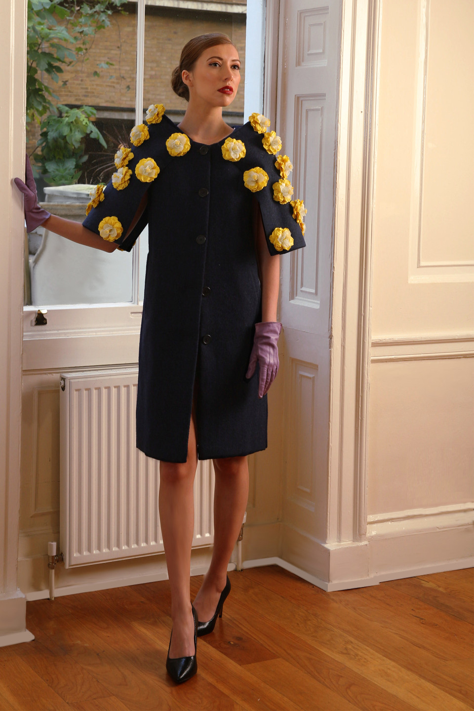 High end coat 100% wool tweed in a navy colour and adorned by silk flowers in yellow